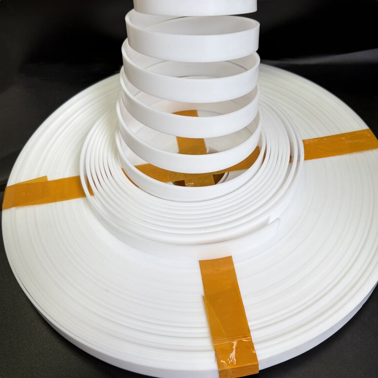 White PTFE guide-strip loops rising from a wound coil